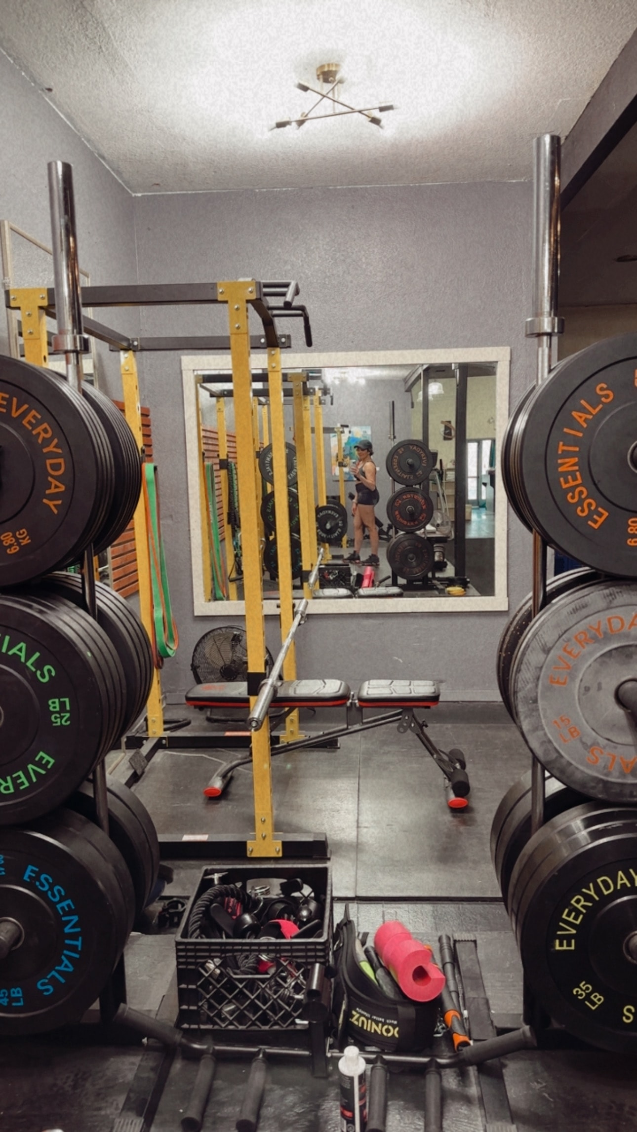 Yvette training in her gym, framed by weight racks and equipment